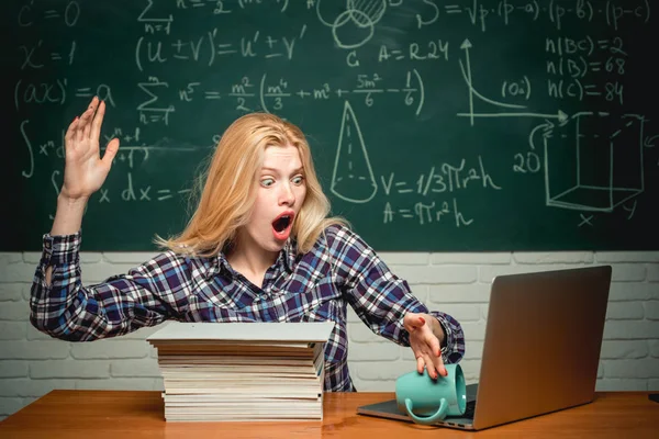 Dizüstü bilgisayarlı öğrenci. Eğitim. Öğrenci masada oturuyor ve not defterine yazıyor. Öğrenci kızgın. Ağlayan duygusal kızgın kadın öğrenci sınıf tebeşir tahtası arka plan üzerinde çığlık.