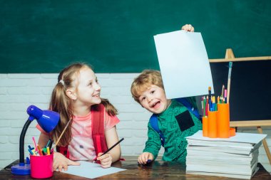 Okula ve mutlu zamanlara geri dönelim. Okul bahçesindeki ilkokuldan bir oğlan ve kız. Chalkboard kopyalama alanı - okul konsepti.