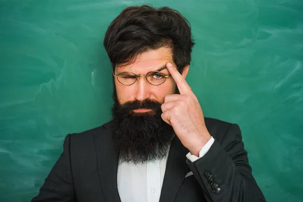 De vuelta a la escuela y tiempo feliz. Retrato del profesor barbudo en la clase de la escuela en los escritorios en el aula - de cerca . — Foto de Stock