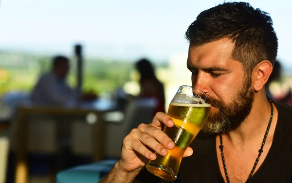 Happy smiling man with beer. Man drinking beer. Emotional funny bearded drunk hipster holds craft bottled beer.