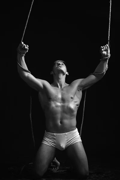 Sexy macho man doen gymnastiek. Man met gespierd lichaam op touw. Circus gymnast bij pilates of yoga opleiding. Sport training voor de bodybuilder. Fitness dieet en flexibiliteit acrobatiek. — Stockfoto