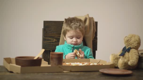 坦率的情绪。真实的时刻。背景。有趣的孩子拒绝吃意大利比萨孤立的白色。孩子反复无常，对食物感到厌恶。垃圾食品男孩熊和比萨饼。不健康的食物. — 图库视频影像