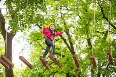 Ağaçlara tırmanan mutlu çocuk. Halat Parkı. Climber çocuğu. Erken çocukluk gelişimi. Roping Parkı. Denge kiriş ve halat köprüler. Halat Park-tırmanış merkezi.