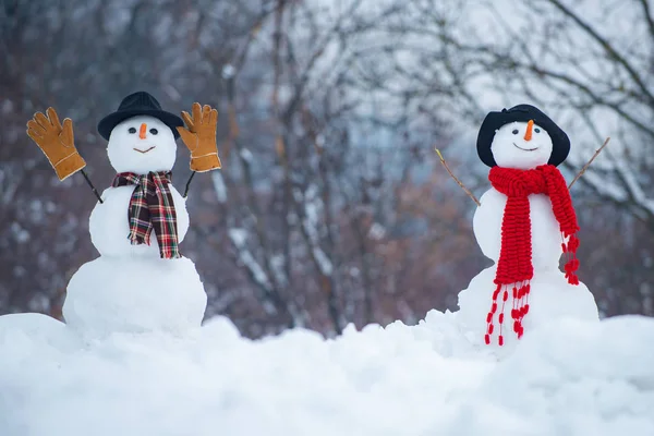 Salut bonhomme de neige. Joyeux bonhomme de neige souriant par une journée ensoleillée d'hiver. Joyeux Noël et bonne année. Deux bonhomme de neige sur fond de neige . — Photo