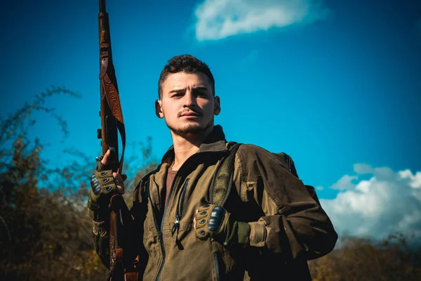 Gros plan Portrait de l'hamdsome Hunter. Braconnier avec fusil repérant des cerfs. Braconnier de chasse illégal dans la forêt. Chasseur avec fusil de chasse sur chasse . — Photo