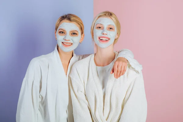 Rutina de mimos. Chicas amigas, hermanas o mamá e hija escalofriantes haciendo mascarilla facial de barro. Máscara anti edad. Mantente hermosa. Cuidado de la piel para todas las edades. Mujeres chicas bastante sonrientes con máscara de arcilla — Foto de Stock