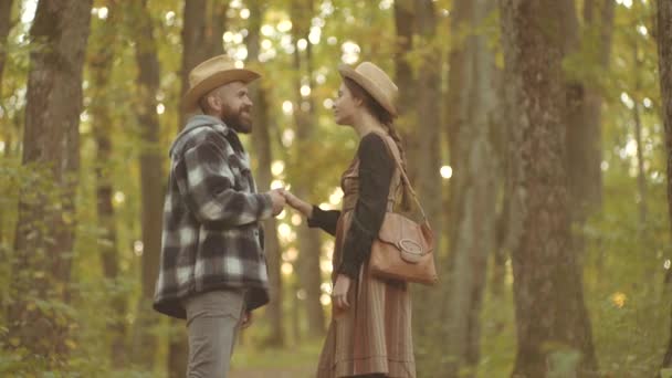 Hösten. Leende par som går över höstens naturliga bakgrund. Ungt par i höst utomhus. Par i retro gammal stil. — Stockvideo