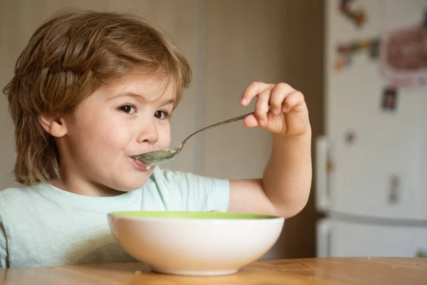 Baby eten eten op keuken. Gelukkig kind. Cute Kid eten. Kleine baby eten. Kleine jongen met ontbijt in de keuken. Hongerige kleine jongen eten. — Stockfoto