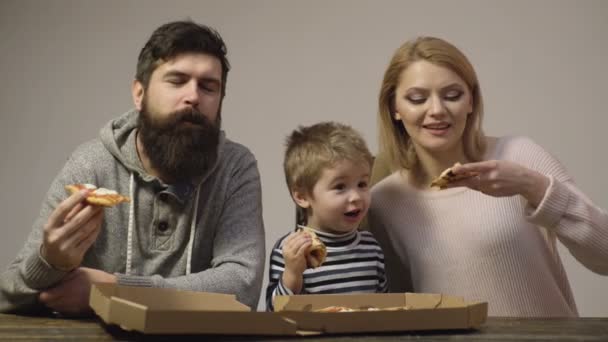 Ernährungskonzept. Leckere Pizza. Mutter, Vater und Sohn essen gemeinsam Pizza auf weißem Hintergrund. Glückliches Familienkonzept. Porträt einer Familie, die sich Pizza teilt. Rückrunden. Mann, Frau, Junge genießen Pizza. — Stockvideo