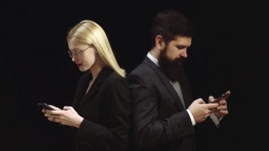 Cep telefonu veya akıllı telefon bağımlısı. Genç iş kadını ve adam müşteri ile konuşuyor. İşadamı ve iş adamının işbirliği portresi. Akıllı telefonu olan bir çift. Bir robotla konuşun.