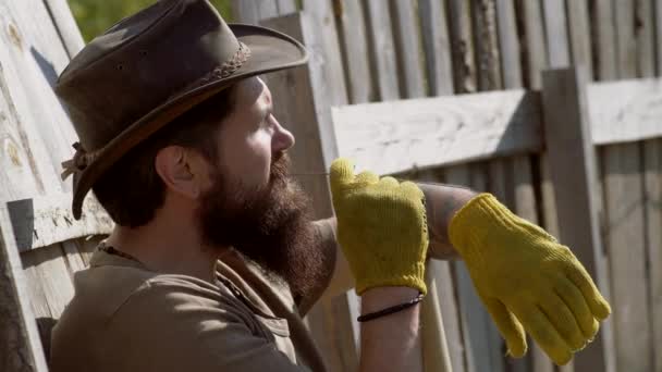 Portrait of handsome young bearded man on spring background. Man farmer concept. Retro farmer man. Eco farm. Full body portrait of bearded man farmer with shovel having fun in a farm. — Stock Video