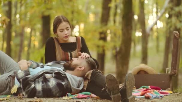 Podzimní pár. Dvojice, která seděla na podzim, spadly do parku. Usmívající se dvojice se baví v podzimním parku. Bavíte se hezky na víkend. — Stock video