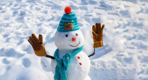 Feliz año nuevo. Fondo de Navidad con muñeco de nieve. Feliz muñeco de nieve divertido en la nieve. Muñeco de nieve hecho a mano en la nieve al aire libre. Muñeco de nieve sobre un fondo cubierto de nieve ramas de abeto . — Foto de Stock