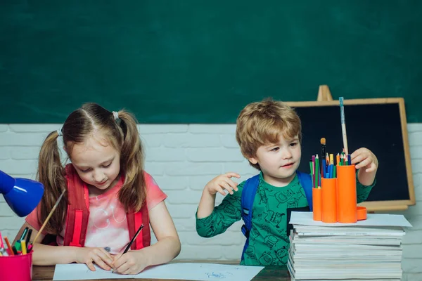 Torniamo a scuola. Bambino vicino alla lavagna in classe scolastica. Divertente bambino che si diverte sullo sfondo della lavagna . — Foto Stock