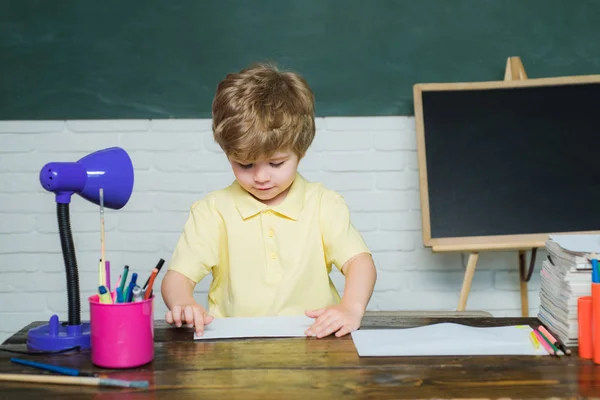 Thuis-of schoolonderwijs. Portret kind van de lagere school. Grappige kleine jongen die op Blackboard wijst. Concept van het onderwijs en het lezen. — Stockfoto