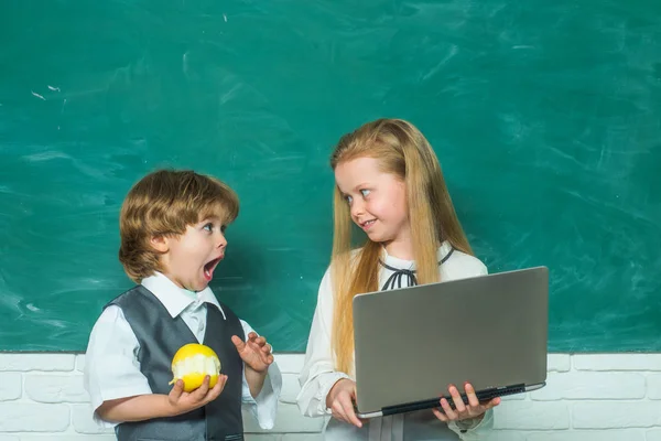 Professor e criança. Miúdos da escola primária. Menino e menina da escola primária no pátio da escola. Miúdos da escola. Casal de menina e menino na sala de aula. — Fotografia de Stock