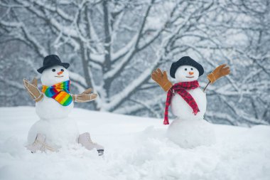 Kardan adam bir arka plan karla kaplı köknar dalları. Kar ormanında kardan adam. Snowmen. Kardan adam kar arka planda izole. Kardan adam ve kar günü.