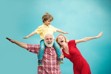 Aile üretimi ve ilişkiler konsepti. Büyükbaba emekli. Büyükbaba ve anne ile küçük torunu mavi yaz gökyüzünde oynuyor. Dedem ile komik zaman. Eski ve Genç.
