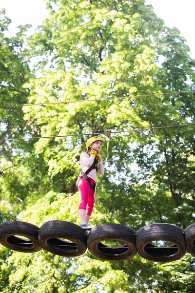 かわいい女の子の男の子。ヘルメットと安全装置。すべての子供時代が重要です。幼児幼稚園。作品は、飛ぶキツネやクモのネットを含むエコリゾートでのゲームを描いています. — ストック写真