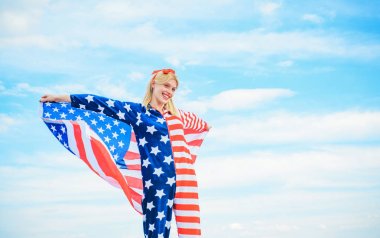 Mavi gökyüzü arka planda Amerikan bayrağı tutan genç kadın, kırmızı, beyaz ve mavi kostüm giyiyor, Amerika Birleşik Devletleri Bağımsızlık günü kutluyor. 4 yılında mutlu Amerikan vatansever yetişkin kız