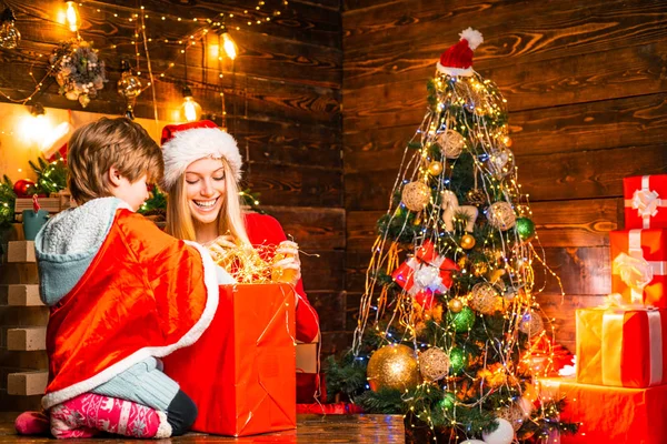Serviço de Decoração Familiar. Irmã mais nova com um menino está ajudando na instalação de luzes de Natal . — Fotografia de Stock
