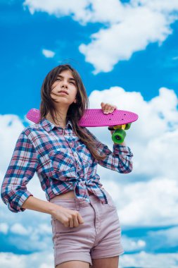 plastik mini cruiser kurulu. Bahar. Kentsel sahne, şehir hayatı. kaykay spor hobi. Yaz aktivitesi. sokakta binmek için hazır. Penny tahtasına sahip hipster kız. En sevdiği ulaşım modu