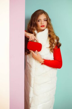 Temel ihtiyaçlarını kolaylıkla taşımak için mükemmel. Moda kız mini kırmızı çanta ile çekici kürk yelek giymek. Moda aksesuarı ile zarif kış giysi genç kadın. Pretty kadın taşıma kutusu debriyaj çantası