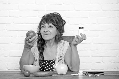 Yaşlı kadın seçin elma ya da hap şişesi