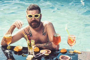 Beyaz adam çıplak, üstsüz, yüzme havuzunda içkili, taze duygularla..