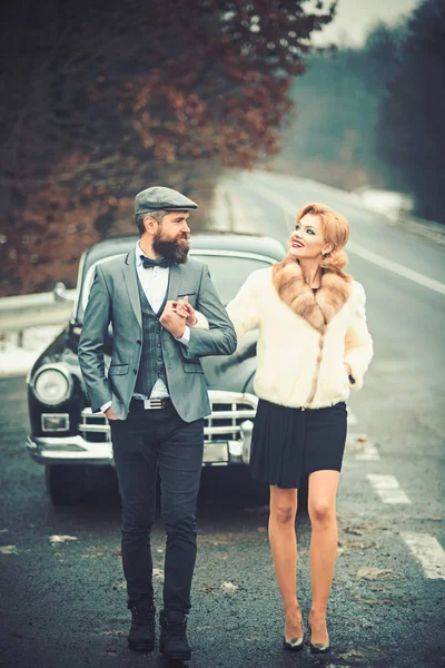 Escolta de rapariga pela segurança. conceito de escolta com motorista barbudo e menina de luxo em carro retro . — Fotografia de Stock