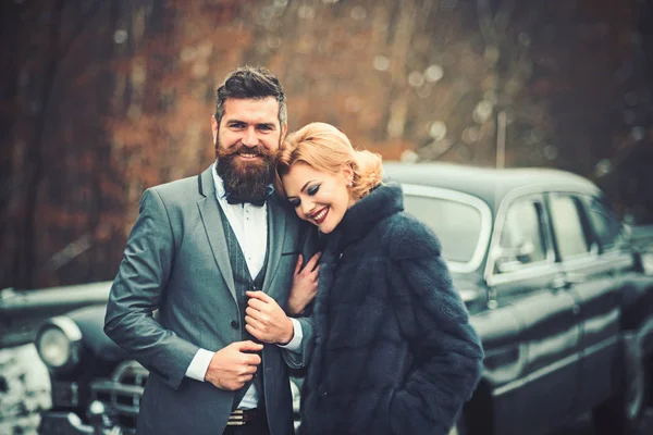 Retro couple at vintage car travelling in winter