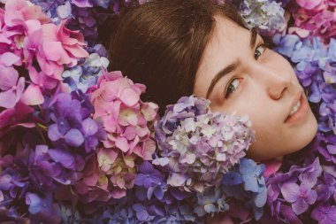 yaz makyajlı kız. Ortanca çiçekleri olan bahar kadını. Yaz güzelliği. Makyaj kozmetik ve cilt bakımı. Kadının moda portresi. Sağlıklı saç ve cilt. Anı yaşamak