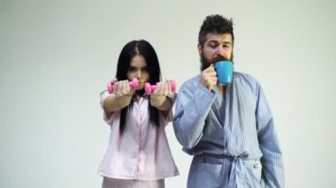 Pijama, bornoz stand sırt sırta aşık çift. Çift, Aile sabah rutin yüzündeki uykulu. Halter, kahve fincanı, beyaz arka plan üzerinde izole adamla olan kız. Sabah enerji kavramı.