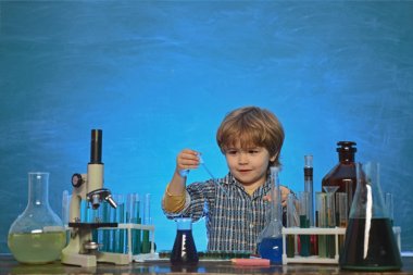 Mutlu gülümseyen öğrenci masada çizim. Mikroskopla biyoloji deneyleri. Küçük bir kimya deneyiydi. Küçük çocuk bilim adamı okul laboratuvarında kimya kazanıyor.