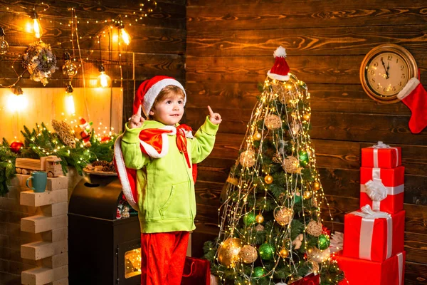 子供は家で冬の休日を楽しむ。喜びと愛に満ちた家。あなたの家族のために最高の願いこのクリスマス。メリークリスマスと幸せな新年。かわいい子供の男の子はクリスマスツリーの近くで遊ぶ — ストック写真