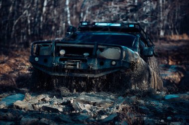 Yol araç kapalı dört tekerlekten sürücü için seyahat ve yarış konsepti. Ormandaki tekerleklerin arasından kar ve çamura giren tekerleklerin lastikleri ve off-road kamyon şaftının ayrıntılı görünümü.