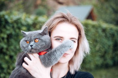 En sevdiğin evcil hayvan. Kız gümüş kabarık kedi taşır. Açık havada evcil hayvan sesi duyarak yürümek. Veteriner dükkanı eczanesi. Veterinerlik konsepti. Hayvanları sever. İngiliz kedisi sevimli gözleri. Eğlenceli sevimli hayvan. Evcil hayvan bakımı