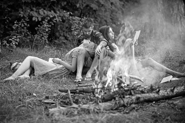 Νεαρό ζευγάρι στην αγάπη, απολαμβάνοντας ρομαντικό Σαββατοκύριακο στη φύση. Γενειοφόρος άνδρας βλέπει την ξανθιά κοπέλα με θαυμασμό. Ομάδα φίλων έχοντας πικνίκ στο δάσος — Φωτογραφία Αρχείου