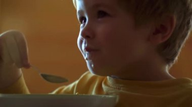 Mutfakta ki çocuk masada yemek yiyor. Bebek yerken. Mutlu çocuk. Mutfakta bebek yeme yemeği.