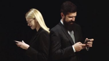 İşyerinde romantizm numarası. İşadamı ve iş adamının işbirliği portresi. Genç gülümseyen iş kadını ve iş adamı siyah arka plan üzerinde izole. Konuş benimle.