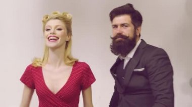 Modaya uygun renk arka plan üzerinde stüdyoda genç komik ve mutlu erkek ve kadın Retro çift. Retro tarz genç çift dokulu arka plan üzerinde birbirlerine bakıyor.