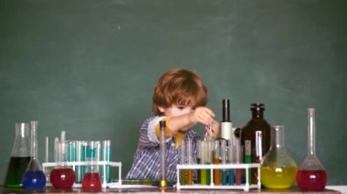 Bilgi günü. Kimya deneyimim. İlkokuldan bir çocuk. Mutlu küçük bilim adamı test tüpü ile deney yapma.
