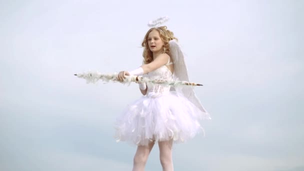 Petite fille portant costume d'ange robe blanche et ailes de plumes. Ange enfant fille aux cheveux blonds bouclés. Petit ange amoureux — Video