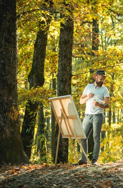 Drawing from life. Painter artist forest. Art concept. Painting in nature. Start new picture. Painter with easel and canvas. Bearded man painter looking for inspiration autumn nature. Relax and hobby