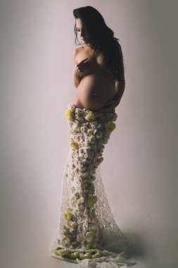 Kadın sağlığı. Koca göbekli kız. Bahar çiçeği etekli güzel hamile kadın. Müstakbel annenin içeride bebeği olacak. Yaşam beklentisi. Sevgi. Hamilelik. Doğum hazırlığı. Anneler Günü