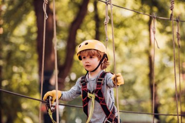 Tasasız çocukluk. Güzel küçük çocuk tırmanma ve macera Park eğlenmek. Parkta ağaçlara tırmanan bir çocuk. Roping Parkı. Kaygısız çocukluk
