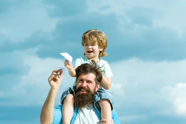 Baba ve oğul birlikte oynuyorlar. Baba ve oğul birlikte kağıt bir uçak inşa ediyor. Baba ve oğul dışarıda eğleniyor. Keyfini. — Stok fotoğraf