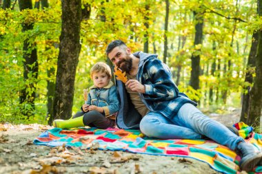 Düşmüş yapraklar. Hipster sevimli oğlu ile baba sakallı ormanda birlikte zaman geçirmek. Aile zamanı. Aile eğlencesi. Acımasız sakallı adam ve küçük çocuk sonbahar doğasının tadını çıkarıyorlar. Aile değerleri. Wanderlust kavramı
