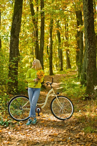 Weekend activity. Active leisure and lifestyle. Girl ride bicycle for fun. Blonde enjoy relax forest. Autumn bouquet. Warm autumn. Girl with bicycle and flowers. Woman with bicycle autumn forest