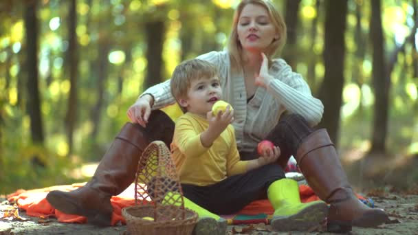Sorrindo mãe e filho andando sobre fundo natural outono. Família natural e saudável sobre fundo outono . — Vídeo de Stock
